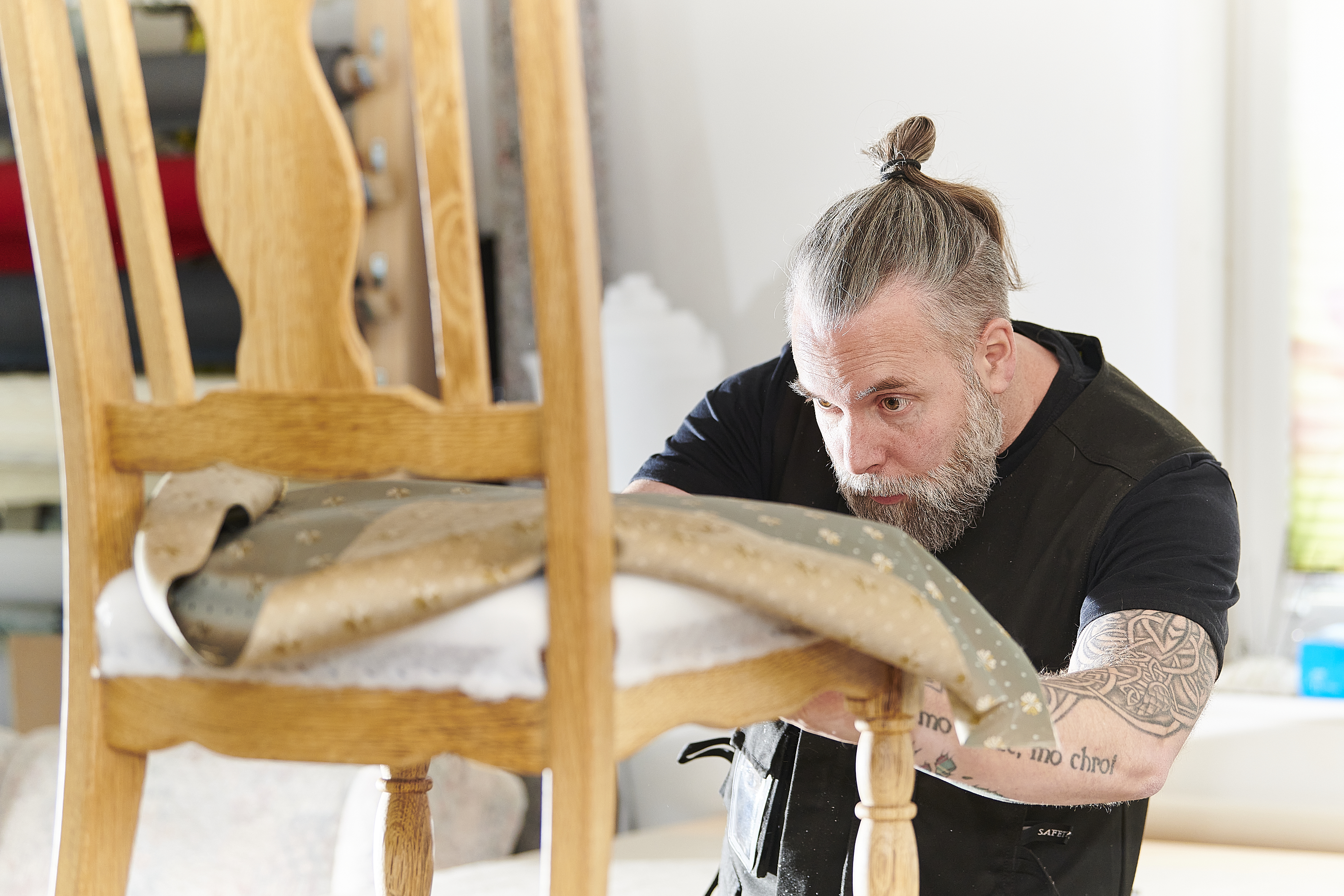 Dennis Mönnekemeyer bezieht einen alten Stuhl mit neuem Polsterstoff.