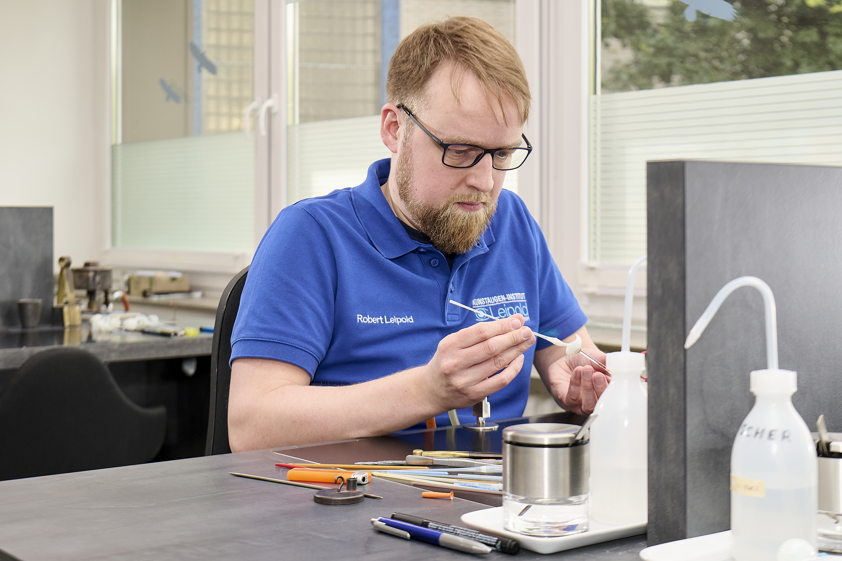 Robert Leipold fertigt ein Kunstauge an.
