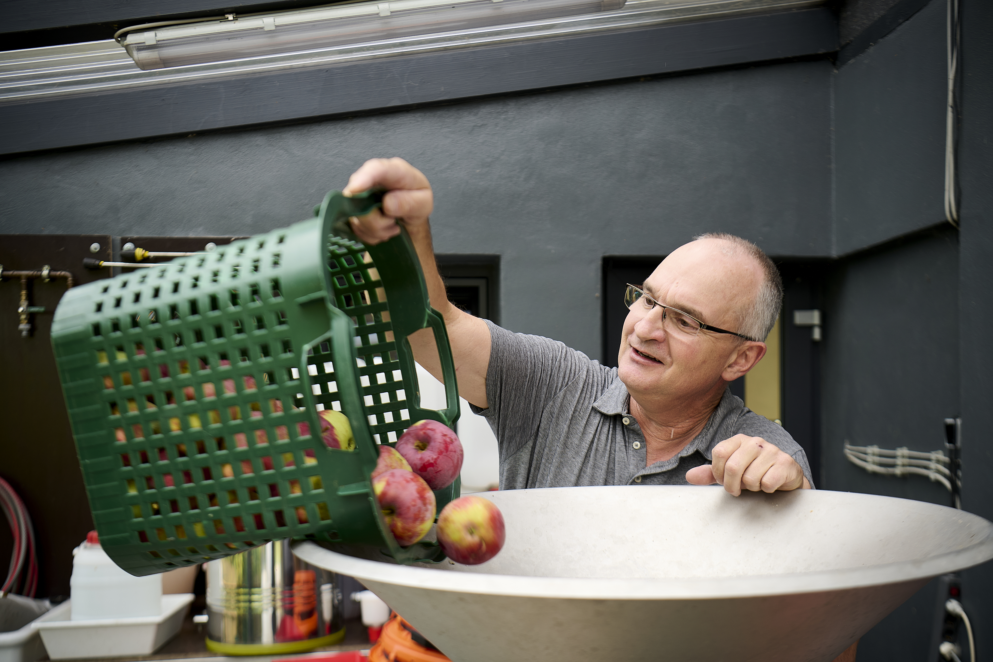 Martin Gerke gefüllt seine Obstmühle mit Äpfeln.