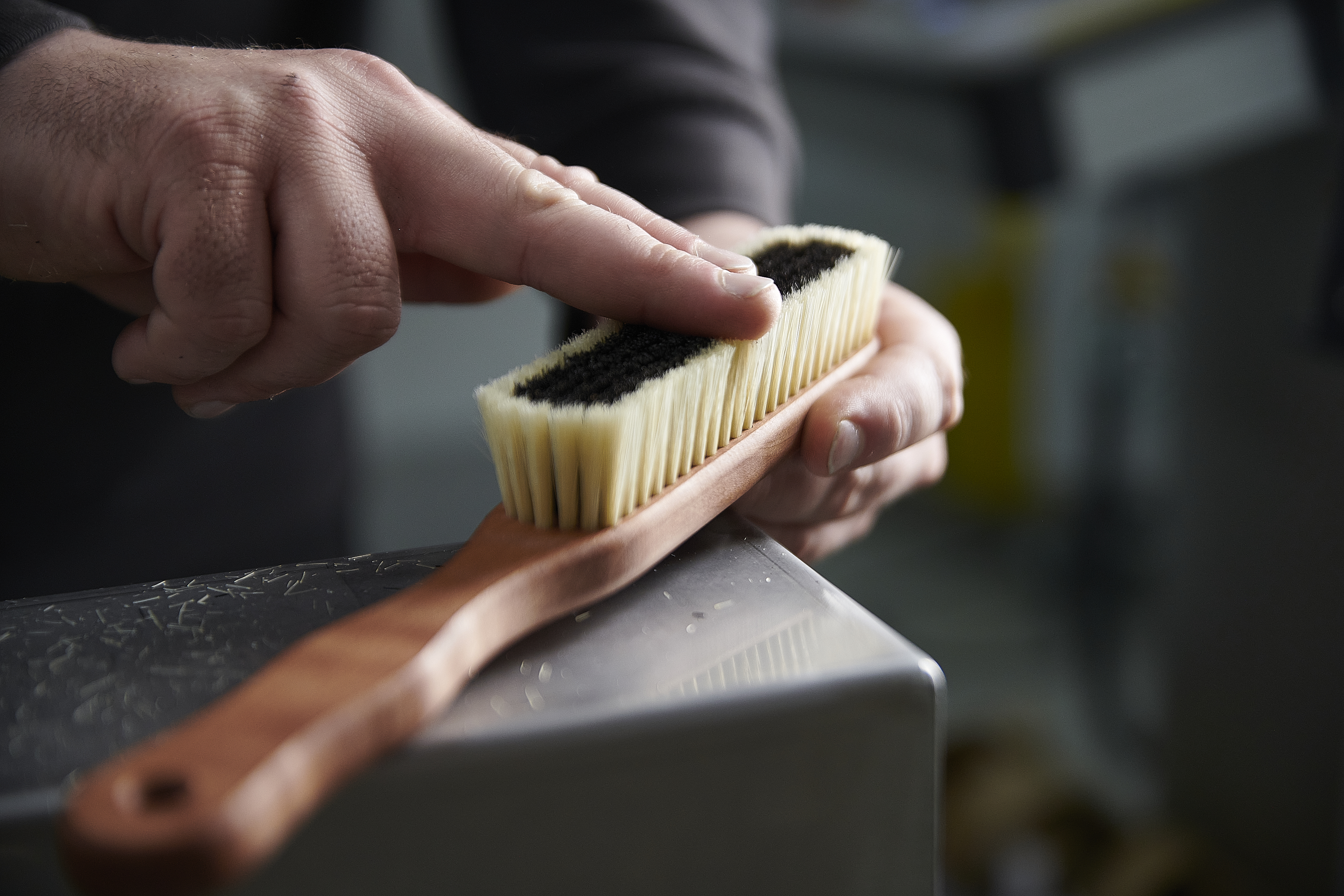 Eine Hand fühlt über eine Kleiderbürste.
