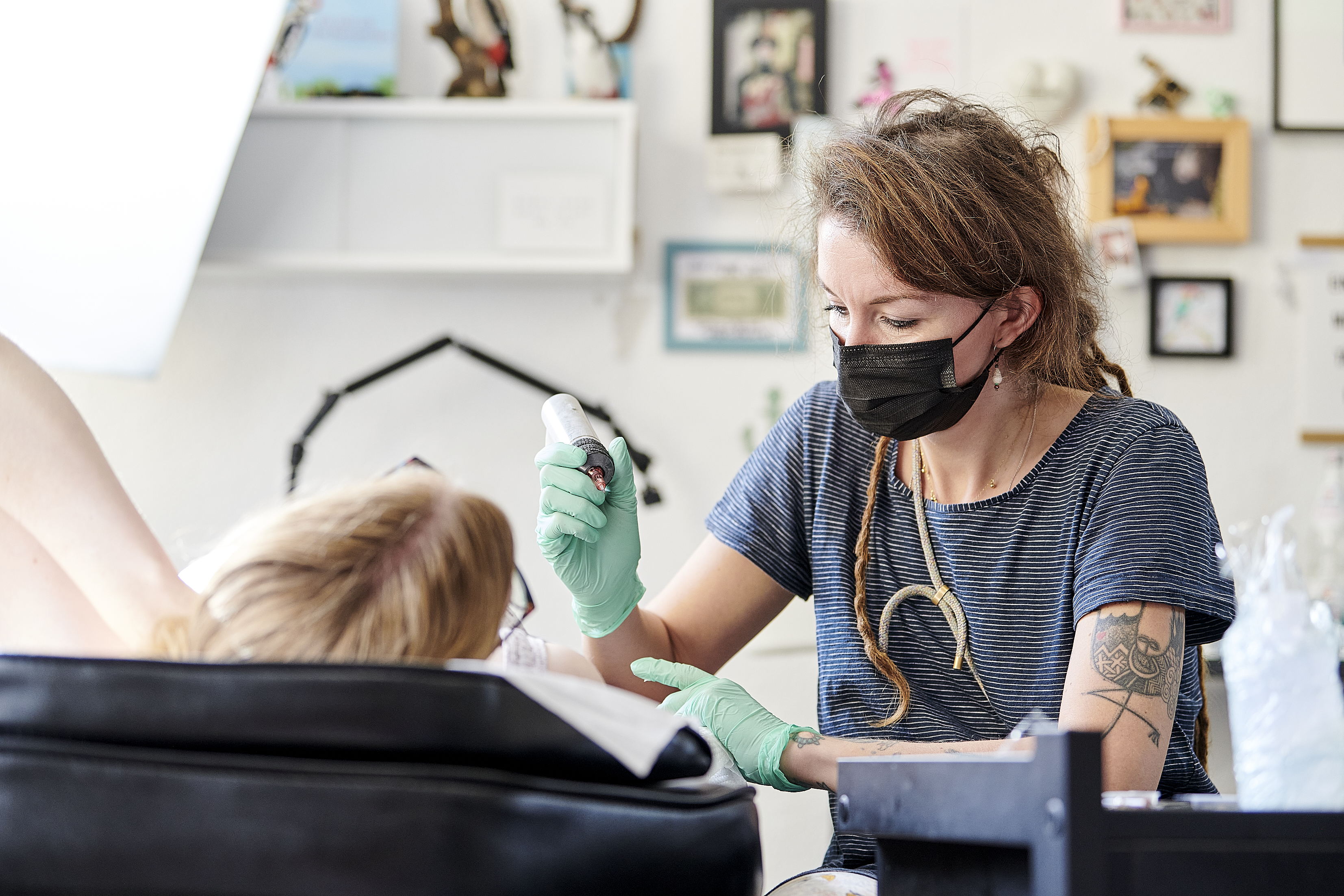 Esther Bühmann tätowiert den Arm ihrer Kundin.